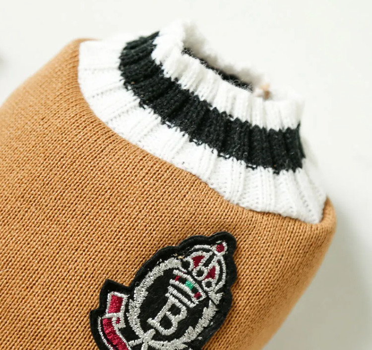 Close-up of the striped neck and badge on the knit cat vest