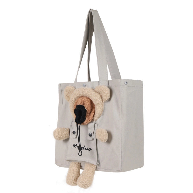 Light grey canvas cat tote seen at an angle, showing the bear opening with drawstring and dangling teddy legs