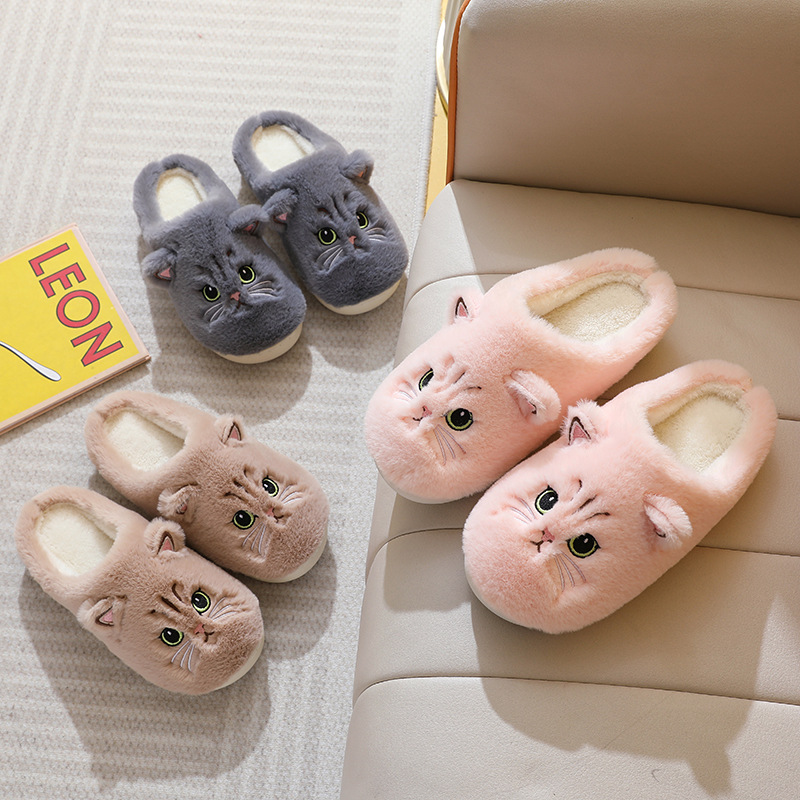 Cat face slippers in several colours on a sofa