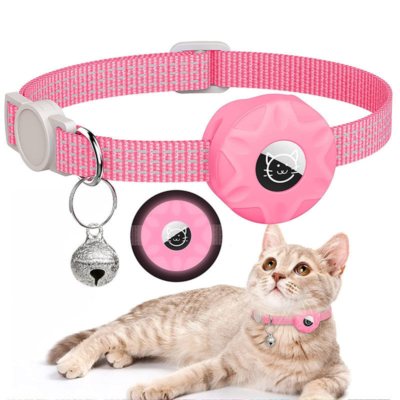 Pink reflective AirTag cat collar with bell, worn by a kitten