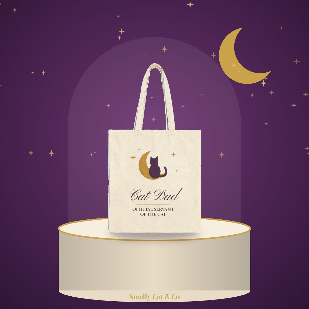 Cat Dad tote bag on a cream podium under a gold moon (product photo on an illustrated background)