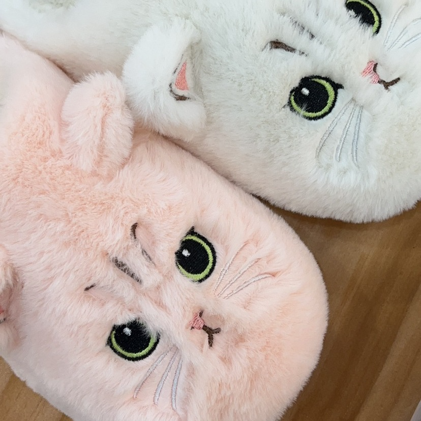 Close-up of the embroidered cat faces on the plush slippers