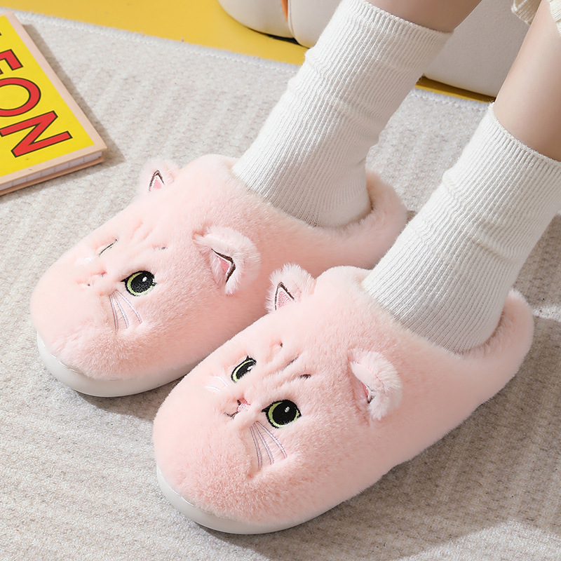 Pink cat slippers being worn with white socks